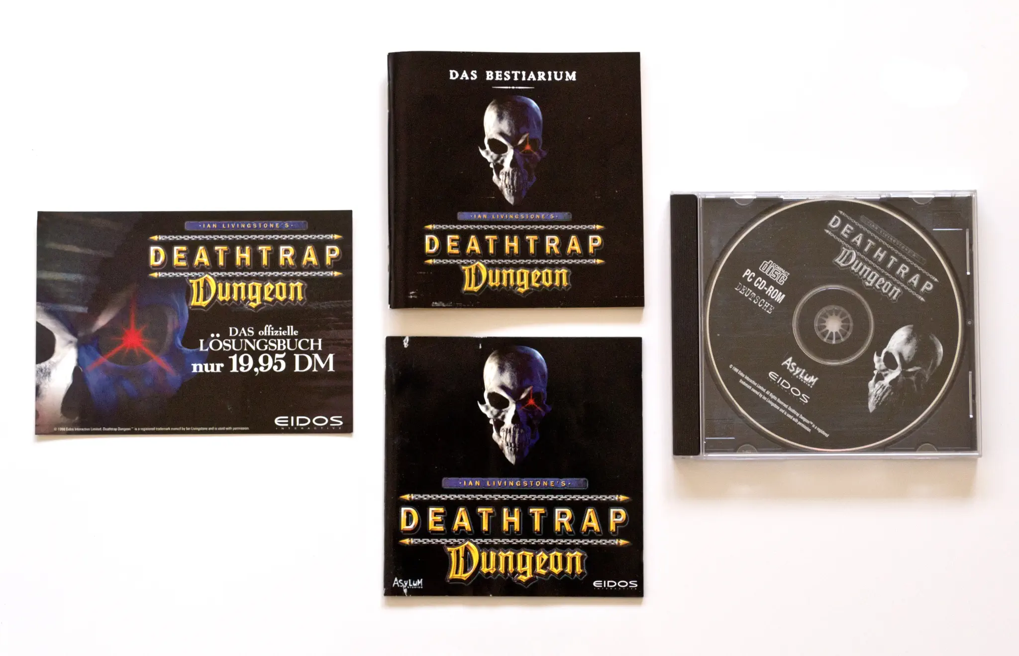 Photo of the content of Ian Livingstone's Deathtrap Dungeon (1998, PC, DE); developed by Asylum Studios, published by Eidos Interactive Limited; Hi-res 3D box available at https://bigboxcollection.com