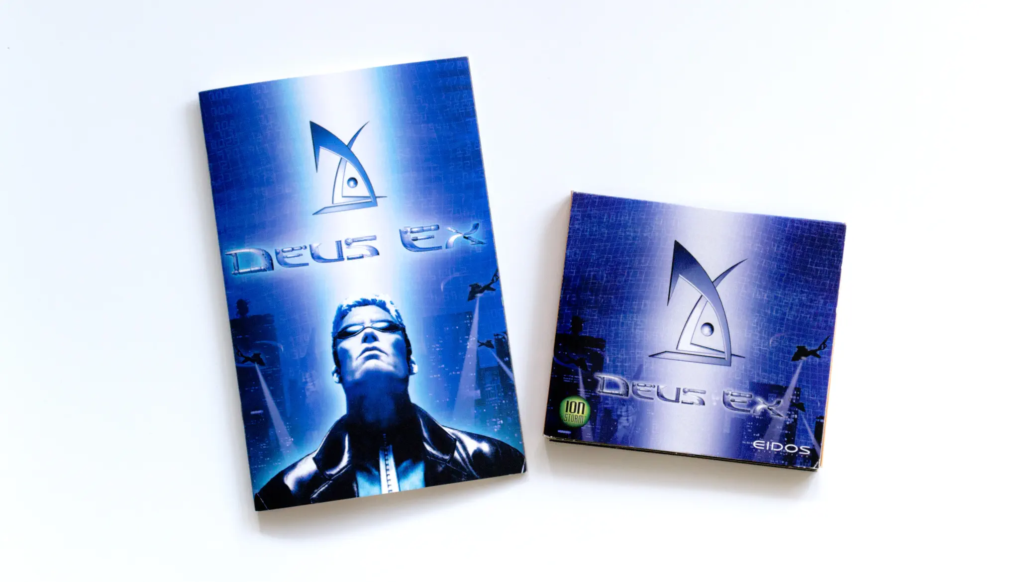 Photo of the content of Deus Ex (2000, PC, US) Photo of the content of Deus Ex (2000, PC, US); developed by Ion Storm Austin, published by Eidos Interactive Limited; Hi-res 3D box available at https://bigboxcollection.com